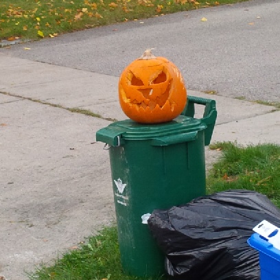 Jack o'lantern on top of a green bin