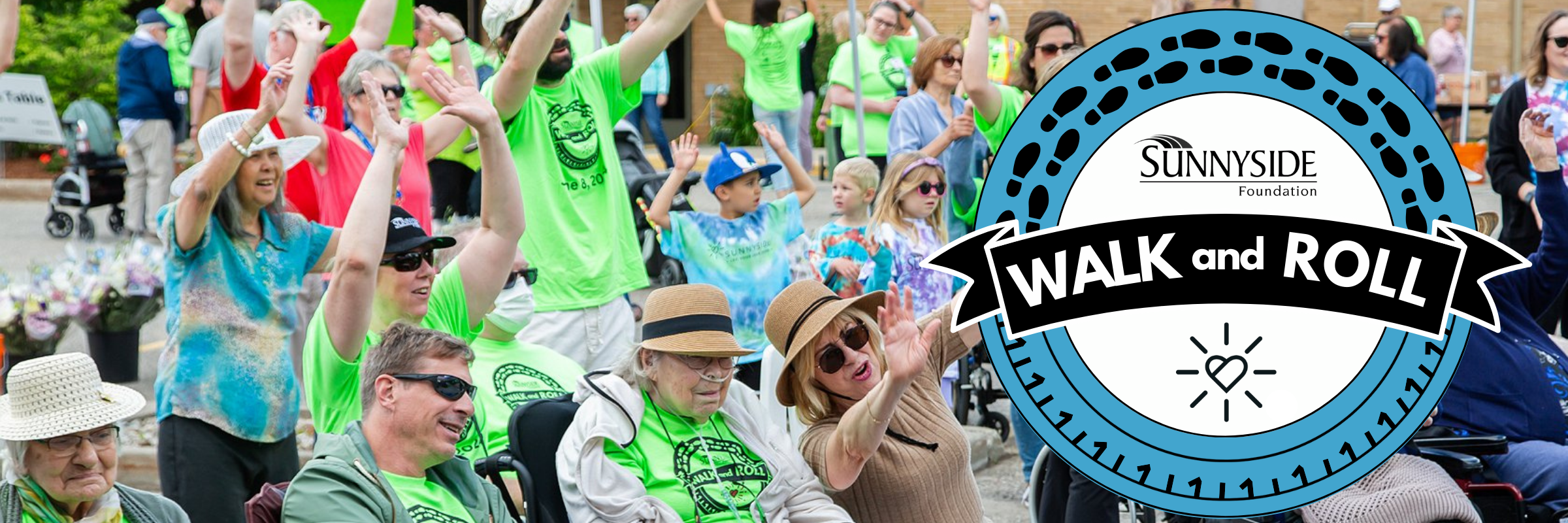 People gathering outside wearing colourful t-shirts and raising their hands in the air. The "Walk and Roll" event logo is over the image.